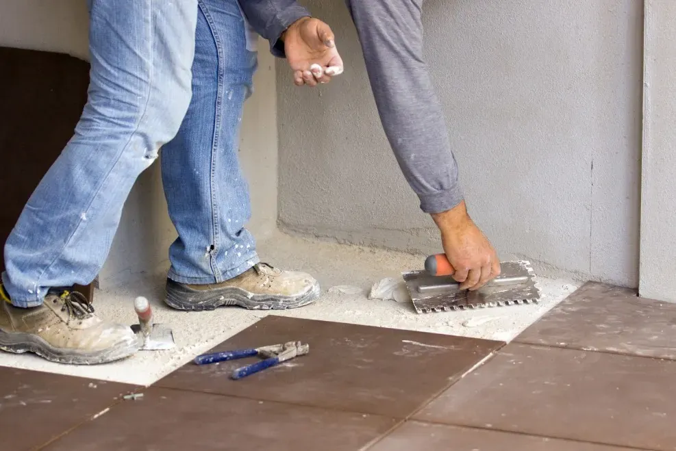 Colocación de baldosas cerámicas en el suelo de una vivienda
