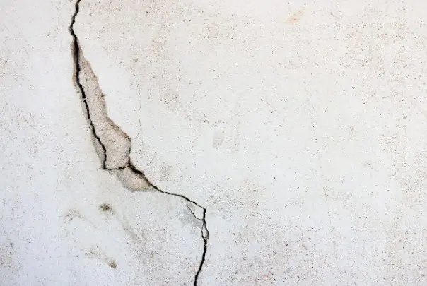 Grieta vertical ramificada en un muro de fachada enfoscado, señal de daño estructural en una vivienda de León