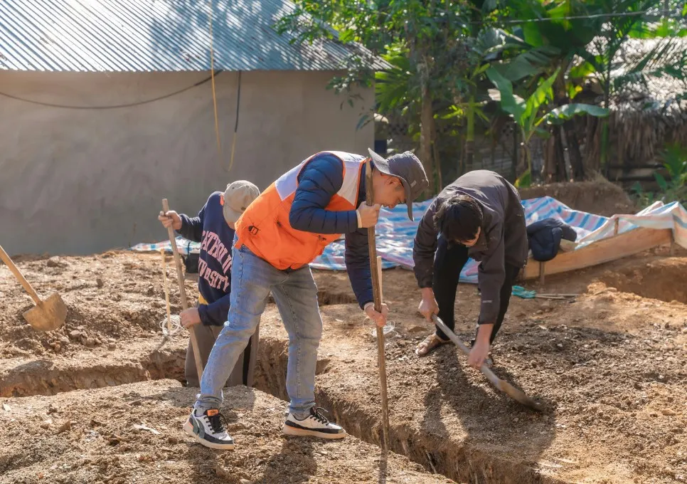 Operarios excavando a mano la zanja de cimentación de una vivienda