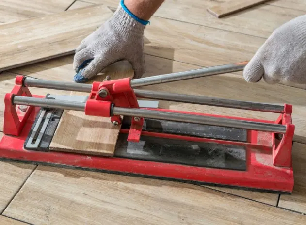 Corte de una baldosa de gres con cortadora manual durante un solado