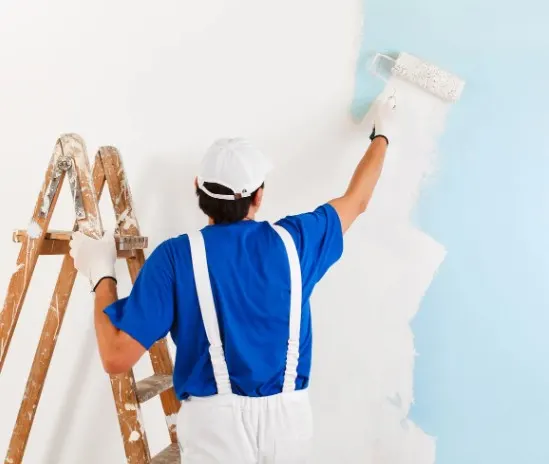 Pintor terminando una pared interior con rodillo tras la reforma, obra ejecutada con todos los permisos en León