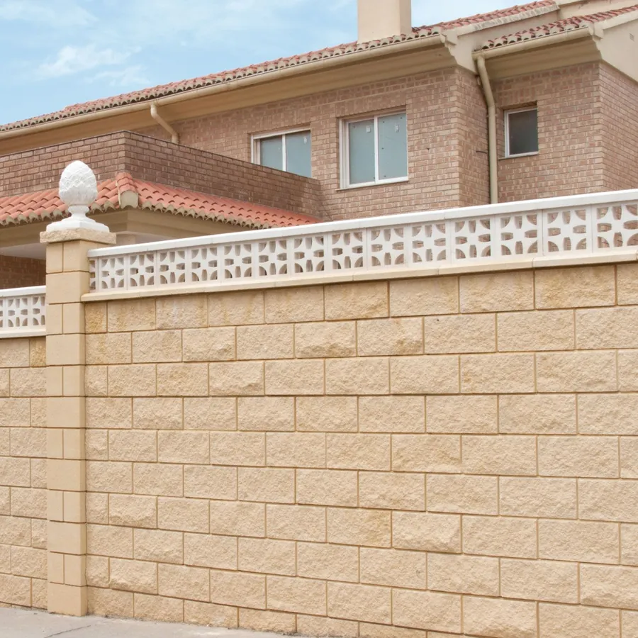 Muro perimetral de bloque símil piedra con celosía y albardilla en un chalet