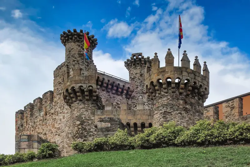 Torres almenadas del Castillo de los Templarios de Ponferrada bajo un cielo azul