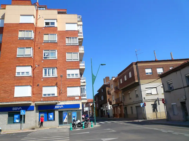 Edificios de pisos de ladrillo con bajos comerciales en una calle de Trobajo del Camino