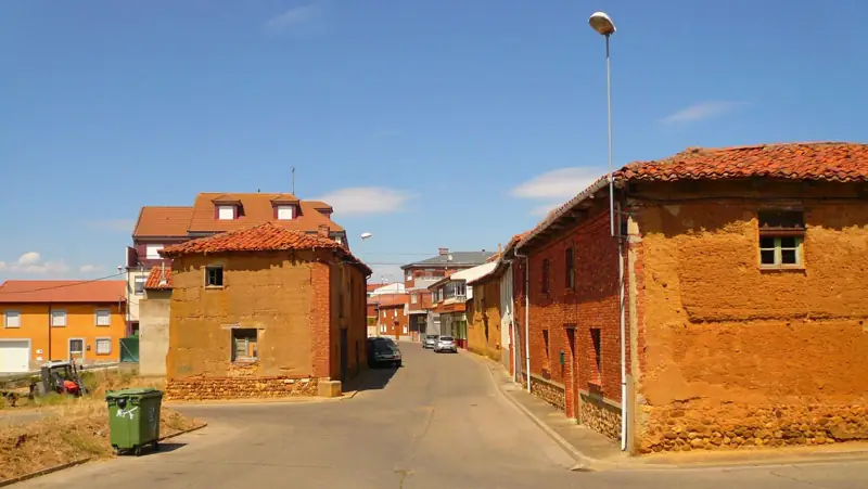 Casas tradicionales de adobe con tejado de teja en una calle de Villaquilambre